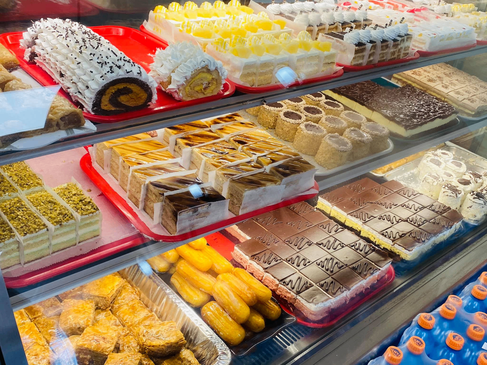 Tray of fresh chocolate-drizzled cream-filled pastries from the bakery