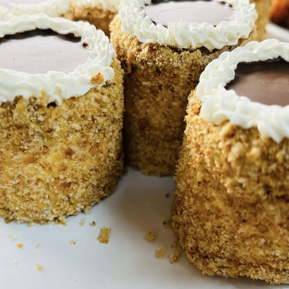 Mini cream cakes with crumb-coated sides and chocolate tops