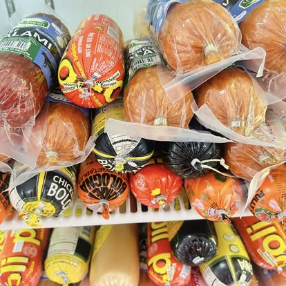 Cooler shelf packed with imported salami, sujuk and cured meat rings