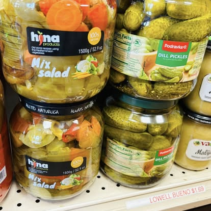 Jars of Hina mixed salad and Podravka dill pickles on the shelf