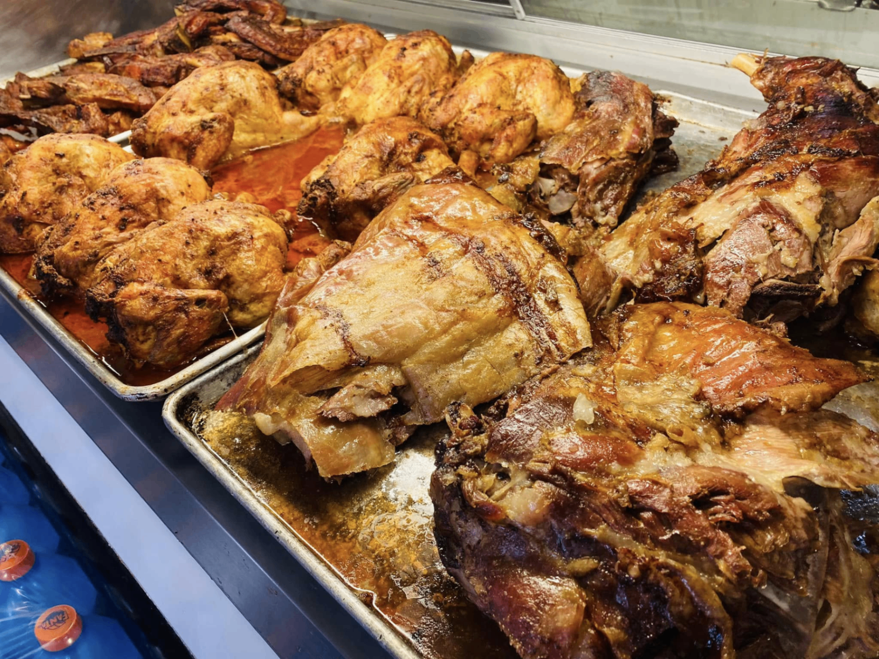 Trays of freshly roasted chicken and lamb on the hot food counter, ready for takeaway