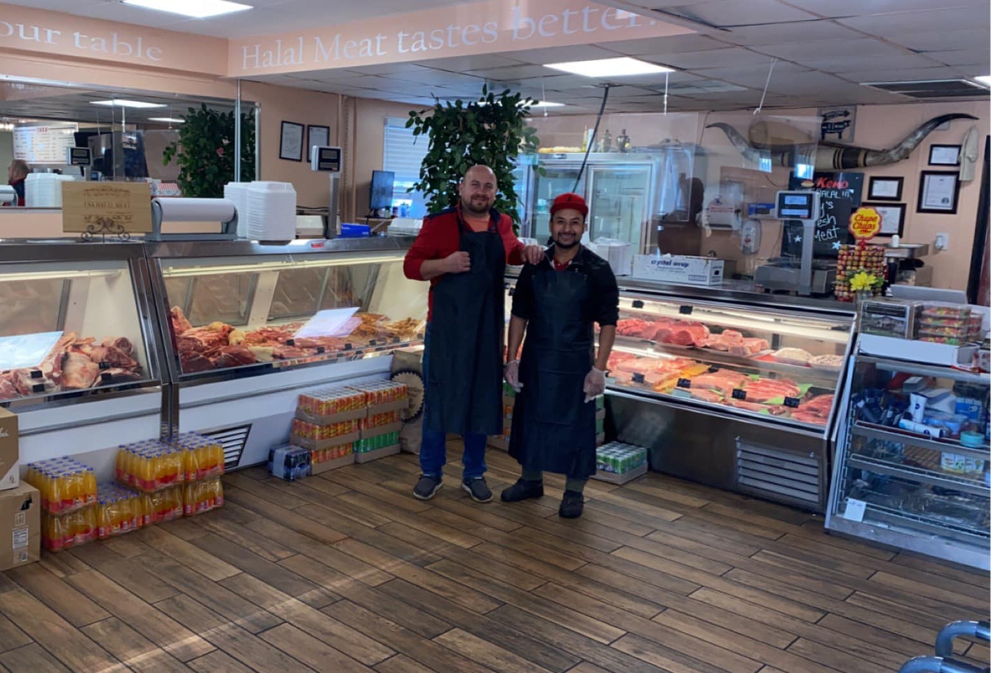 Alen and a butcher behind the meat counter at USA Halal Meat Inc. — fresh halal beef and lamb on display